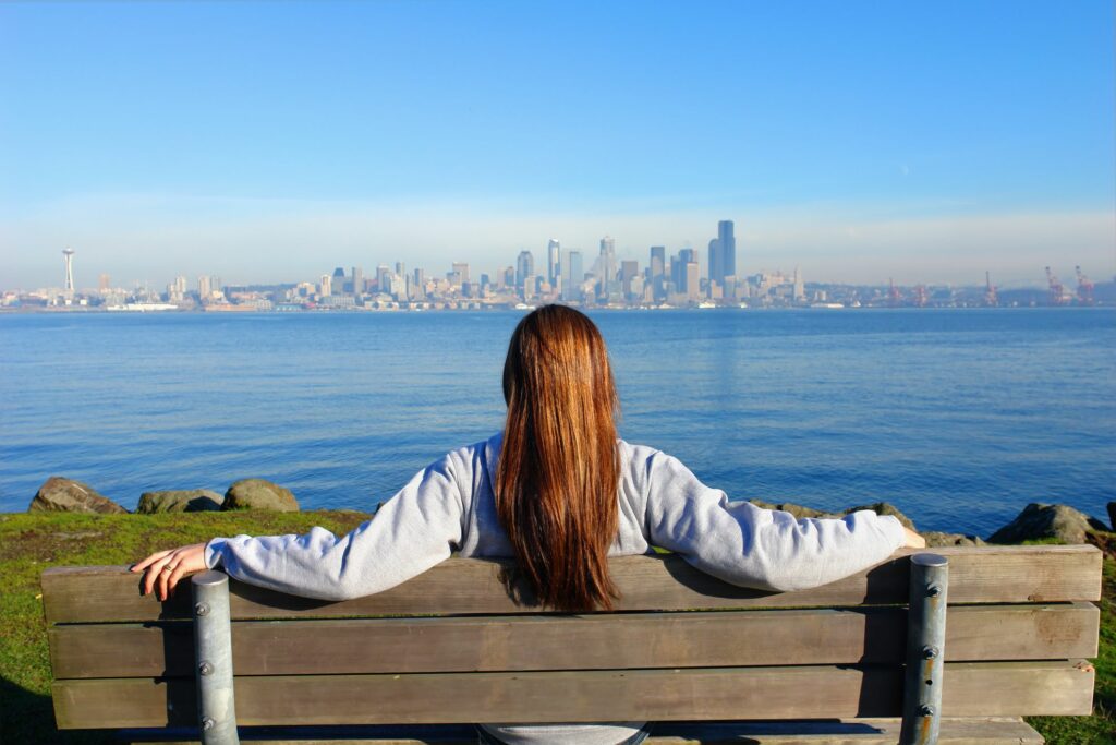 Person enjoying a view of Seattle skyline across a body of water